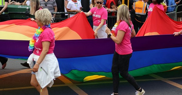 Rainbow pride flags lining a canal-side street in Antwerp, Belgium