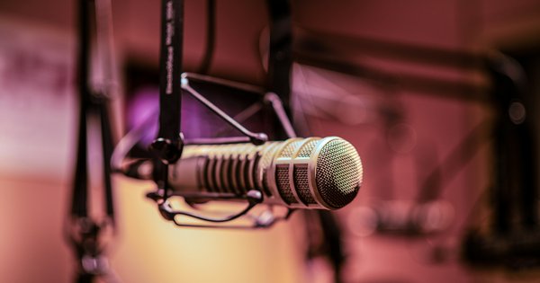 A vintage microphone hanging in a dimly lit recording studio
