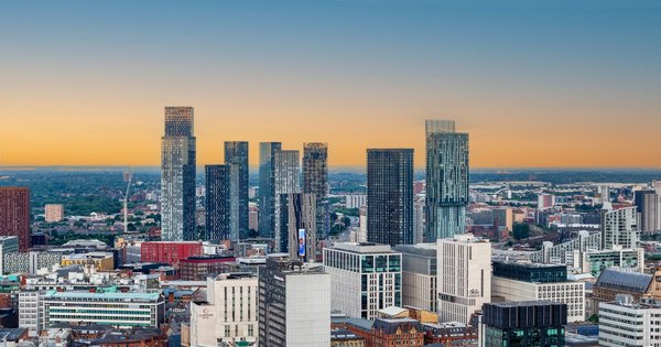 The Manchester skyline with a rainbow pride flag flying in the foreground