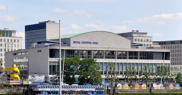 The Royal Festival Hall on London's South Bank, a long modernist concert hall with glass frontage, seen on a bright day