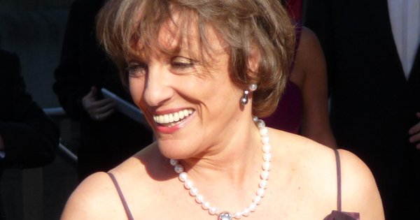 Esther Rantzen smiling at an evening event, wearing a pearl necklace