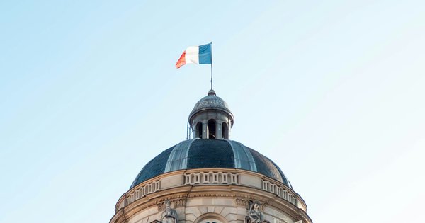 Pride flag flying in a French town square