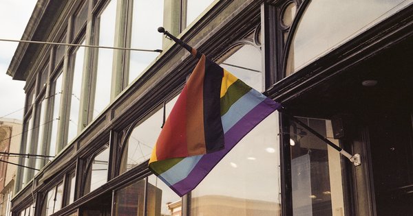 A rainbow pride flag hanging on a building facade in a German city