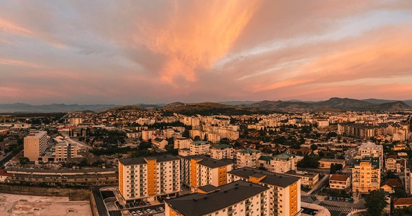 A historic Balkan old town on the water, ringed by mountains