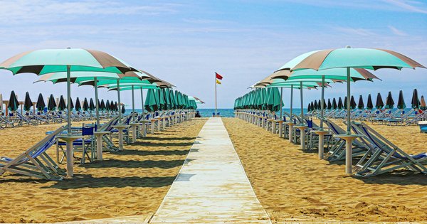 A sandy beach with striped umbrellas along the Tuscan coast near Viareggio