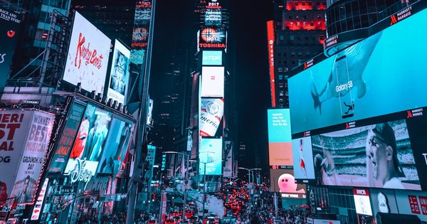 Times Square in New York City at night, lit up with billboards and crowds