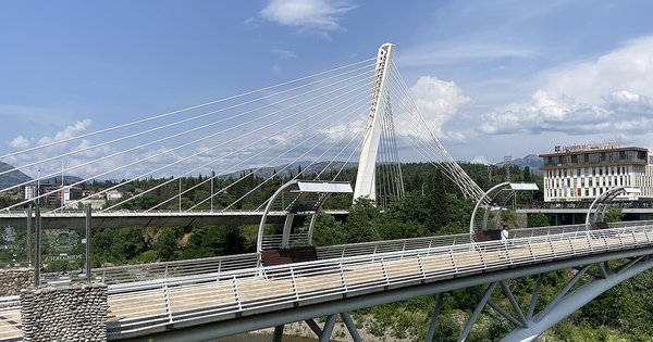 The white cable-stayed Millennium Bridge over the Morača River in Podgorica, Montenegro, under a blue sky