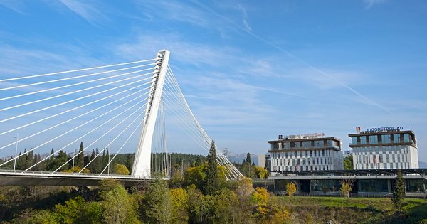 The white cable-stayed Millennium Bridge over the Morača river in Podgorica, Montenegro, under a clear blue sky