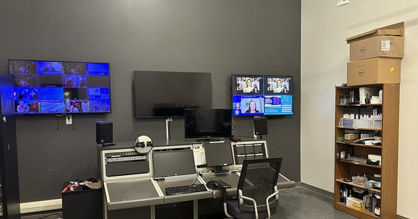 The control room of a television studio, lined with monitors and mixing equipment