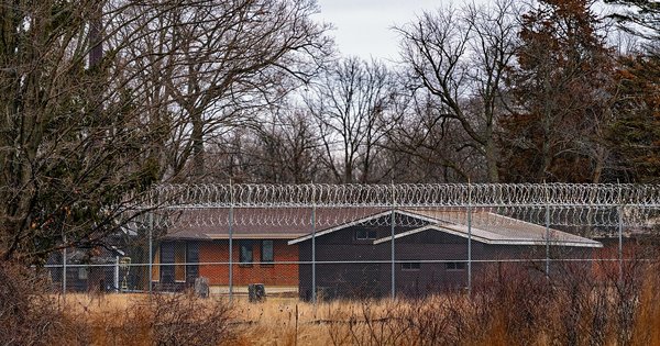 A prison perimeter fence topped with coils of razor wire