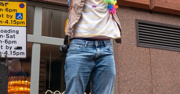A person holding a transgender pride flag at a rally