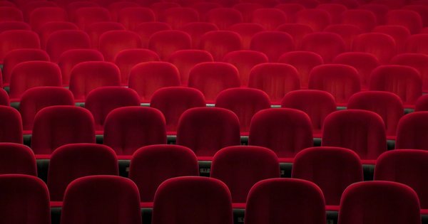 Rows of empty red velvet cinema seats