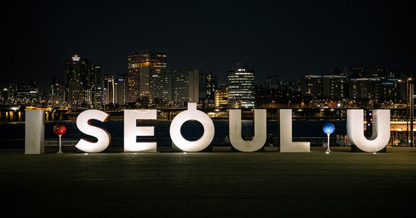 The Seoul skyline at dusk with the city's mountains in the background
