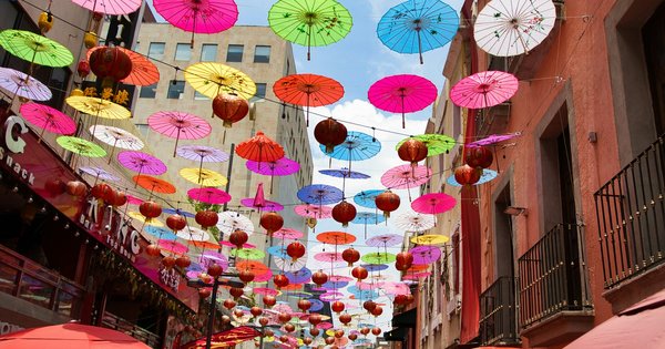 A colorful street in a Mexican city decorated with rainbow flags