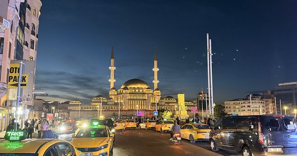 Taksim Square in Istanbul at night, with the mosque and open plaza lit up