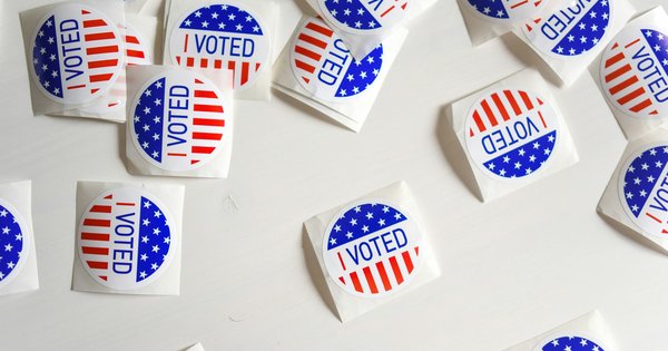 Red, white and blue 'I Voted' stickers scattered across a white table