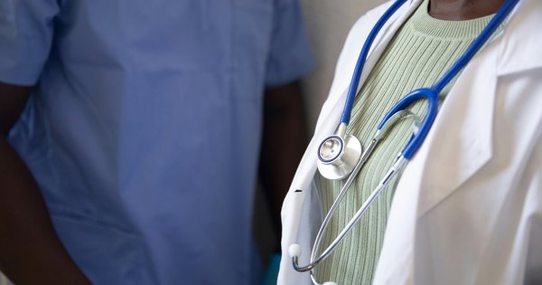 A stethoscope resting on a clipboard in a clinical setting