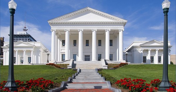 The white-columned Virginia State Capitol in Richmond, with red flowers and green lawns lining the steps