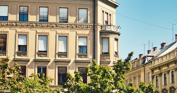 Ornate cream-coloured apartment buildings on a sunny street in Zagreb, Croatia