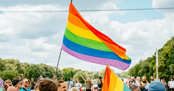 A rainbow pride flag flying against a historic German town square